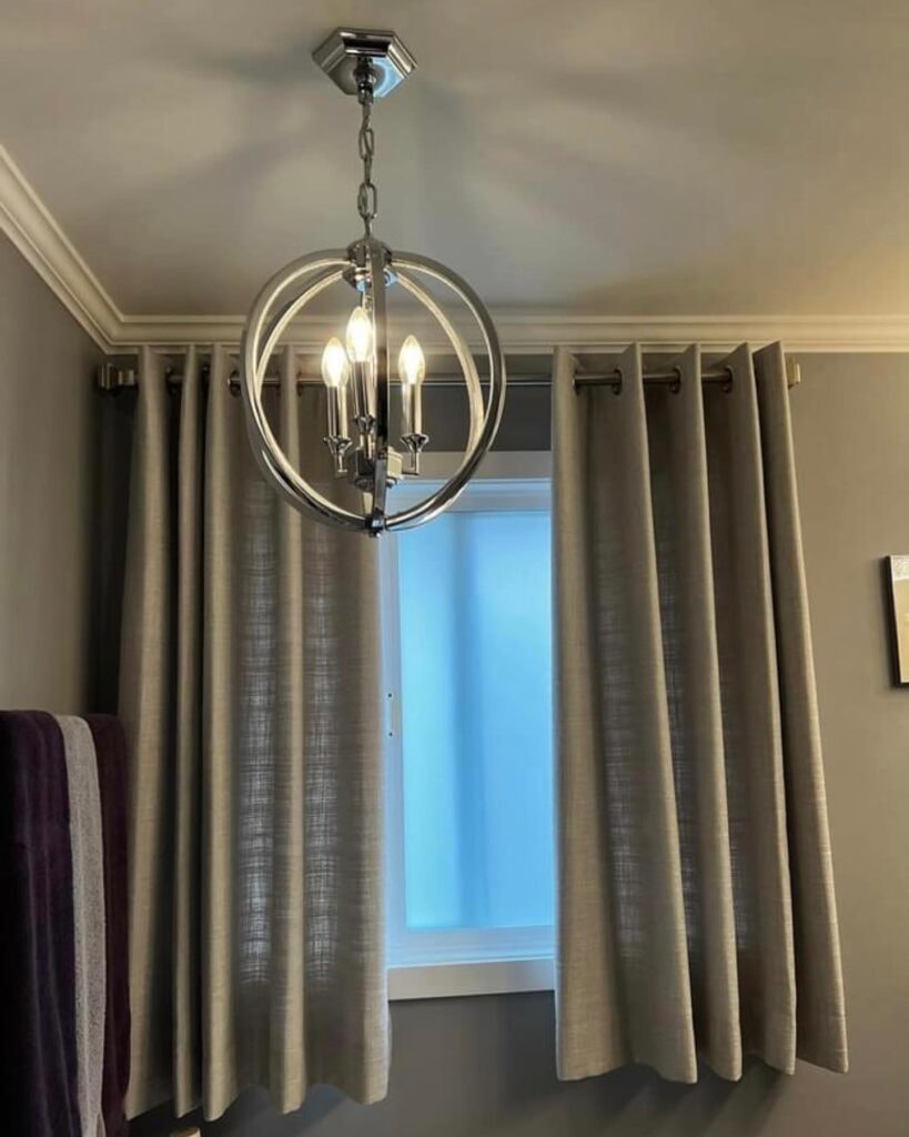 Pendant light with grey grommet drapes in dining room