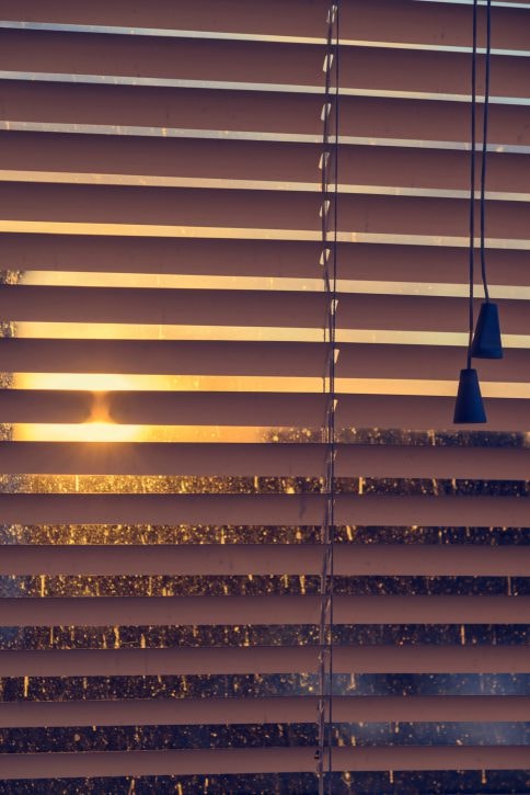 Sunset glow through horizontal blinds with pendant lights