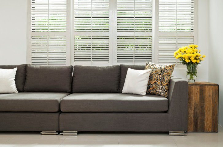 Modern living room with white plantation shutters and grey sofa