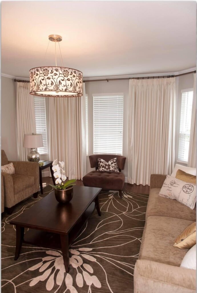 Elegant living room with floor-to-ceiling drapes and drum pendant
