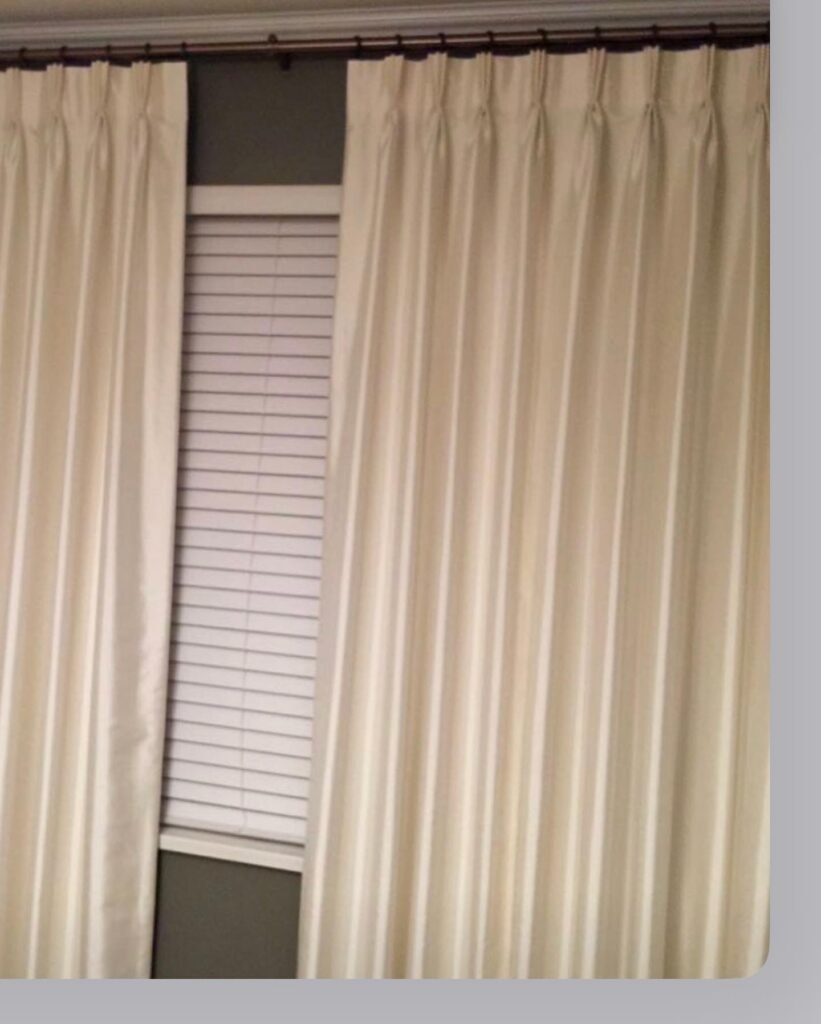 Cream pinch pleat curtains with wood blinds