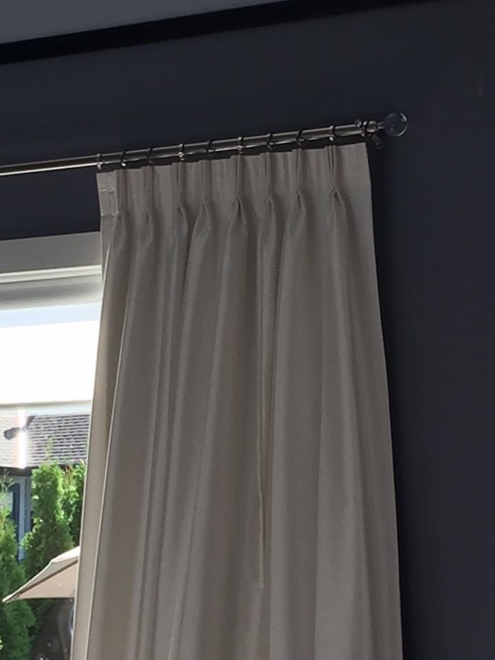 Pinch pleat drapes against dark navy wall